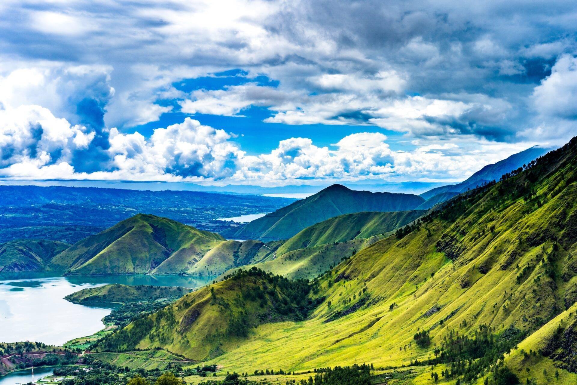 Tropisches Bergpanorama mit Seen, üppigen Wäldern und bewölktem blauem Himmel, Ausdruck der vulkanischen Naturschönheit