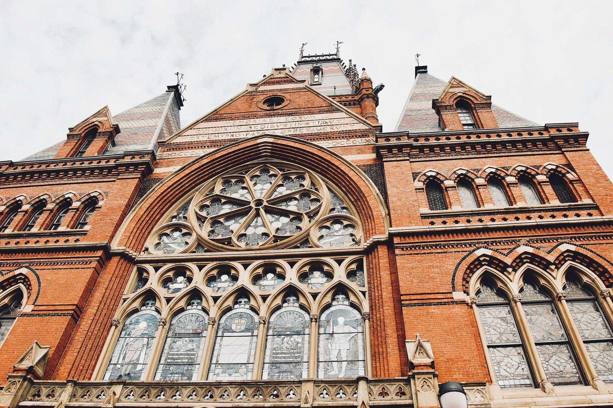 Red-brick facade of a neo-Gothic church with a rose window and detailed architectural ornaments