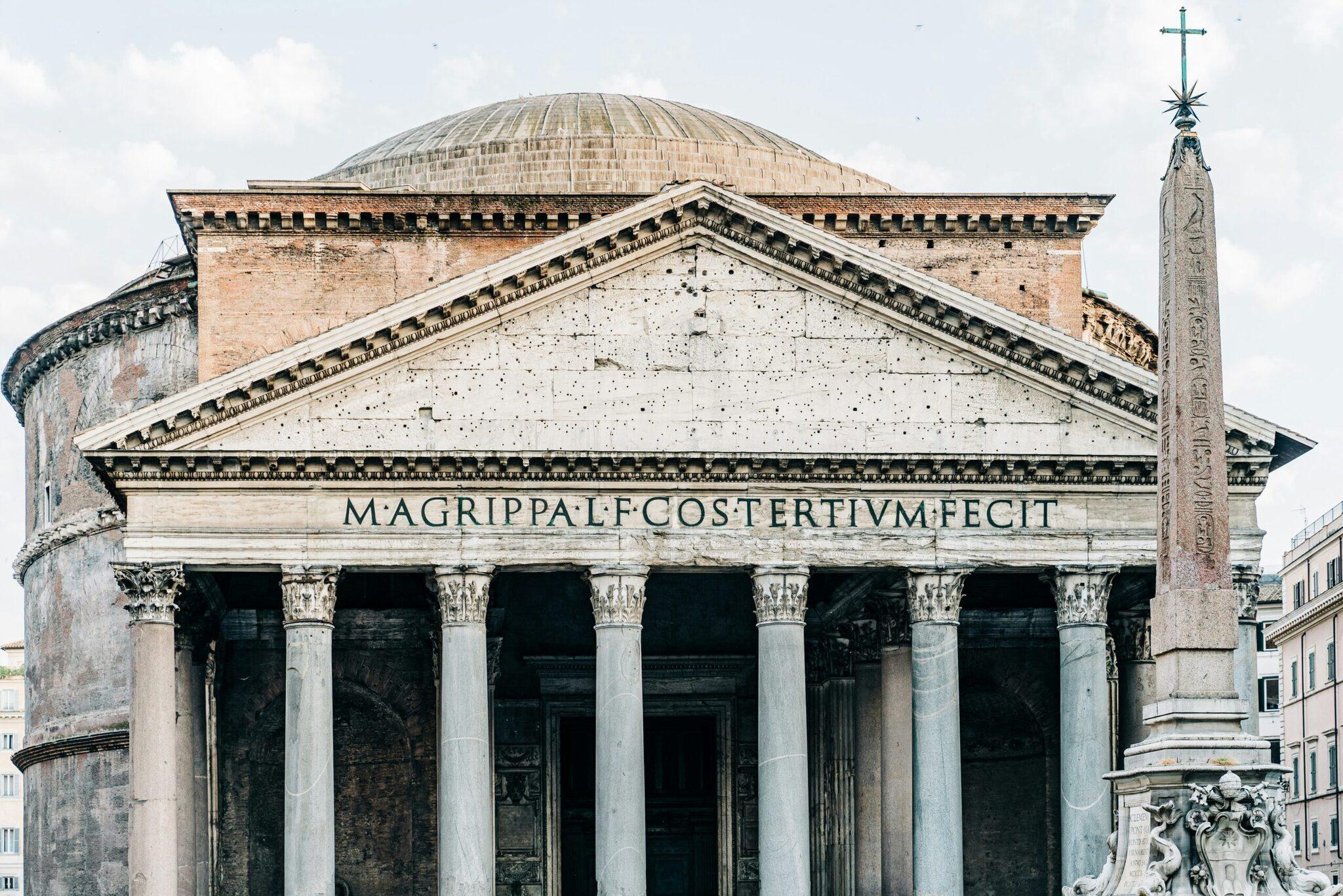 Vista frontal del Panteón antiguo con sus columnas corintias, cúpula e inscripción latina en Roma