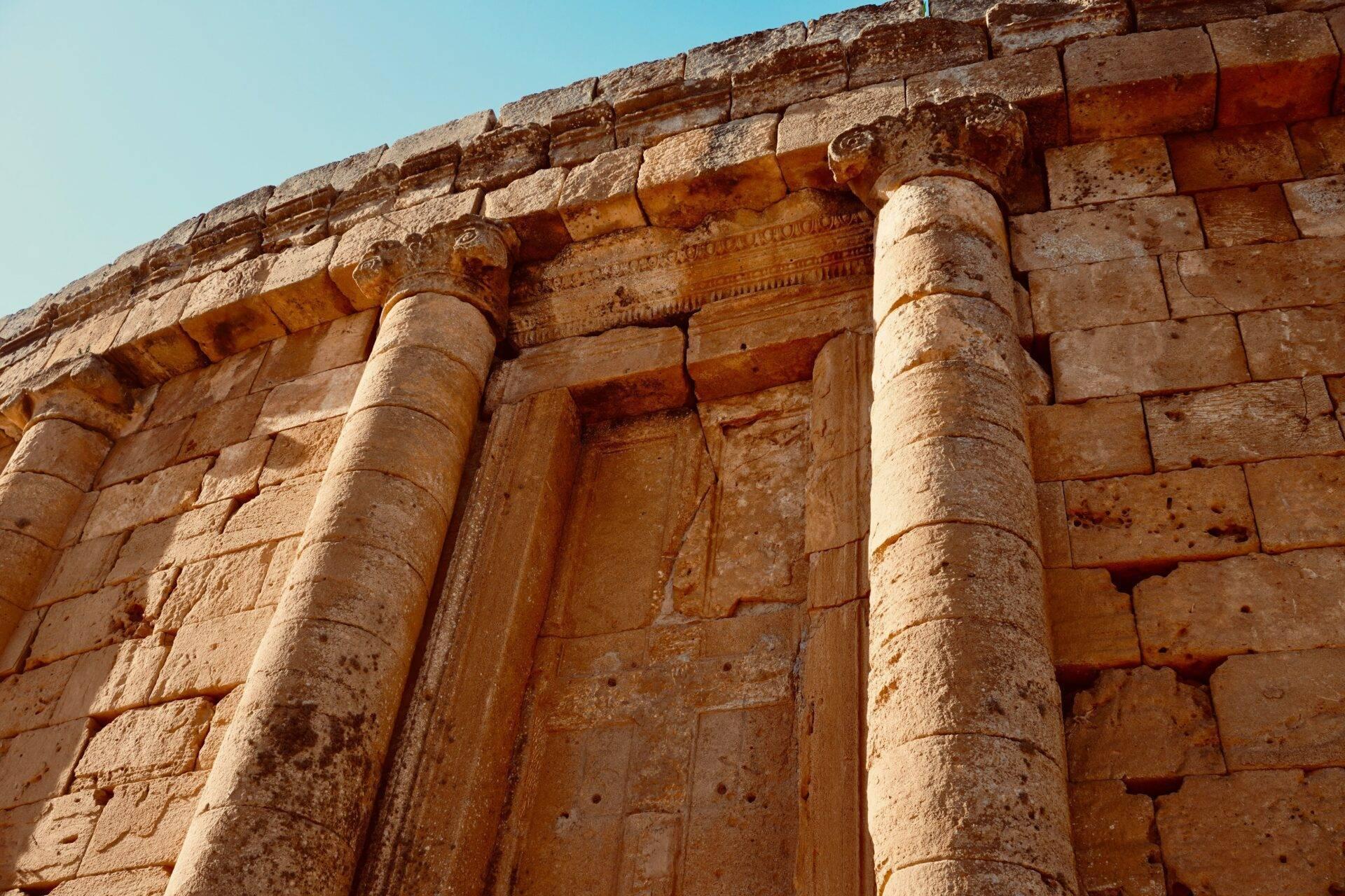 Dettaglio architettonico di un tempio antico in pietra con colonne scanalate e decorazioni scolpite