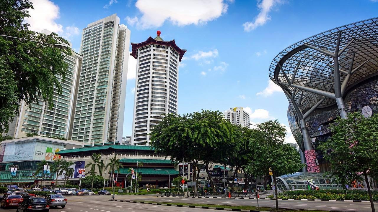 Eine städtische Einkaufsstraße mit modernen Hochhäusern, asiatischem Tempel und zeitgenössischer Architektur unter freiem Himmel