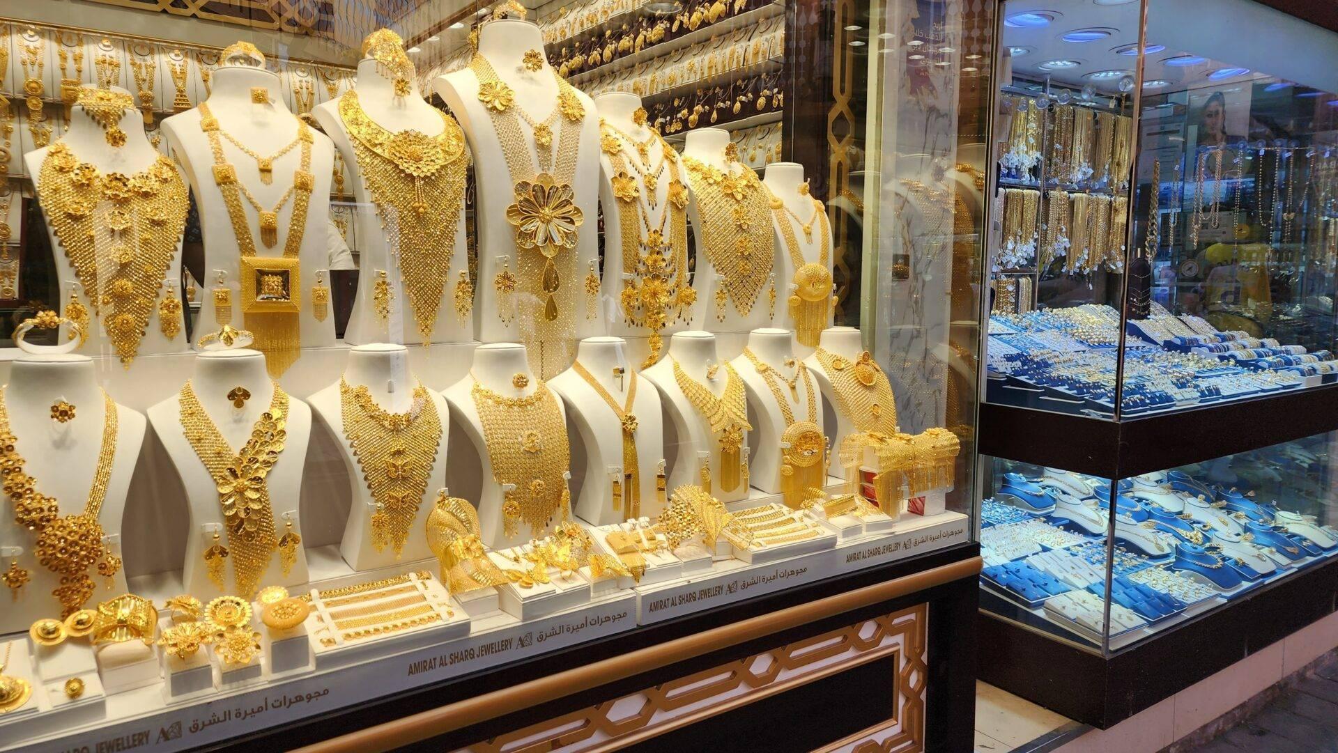 Schaufenster eines Juweliers mit massiven Goldschmuckstücken auf weißen Büsten in einem Luxus-Einkaufszentrum