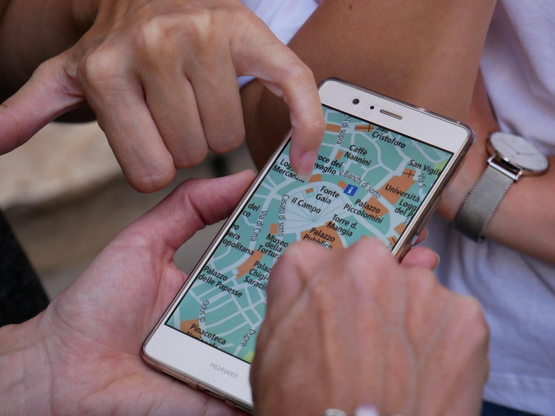 Wanderer, der Maps.me-Offline-Karten auf dem Smartphone in der Natur nutzt, ohne Internetverbindung