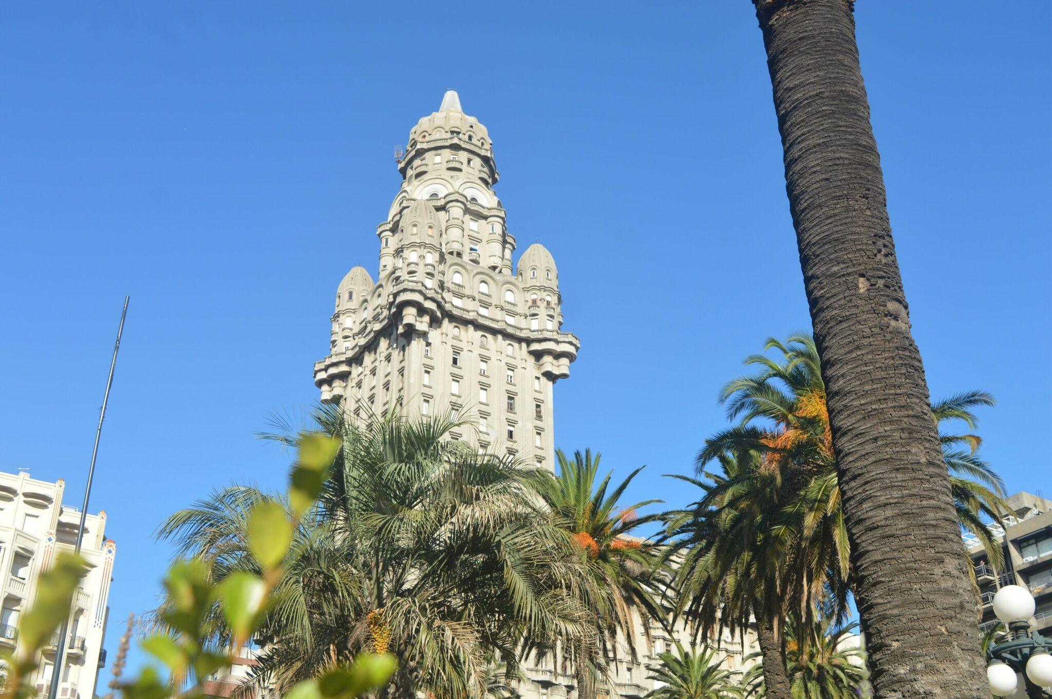 Un maestoso edificio Art Déco bianco circondato da palme sotto un cielo azzurro limpido