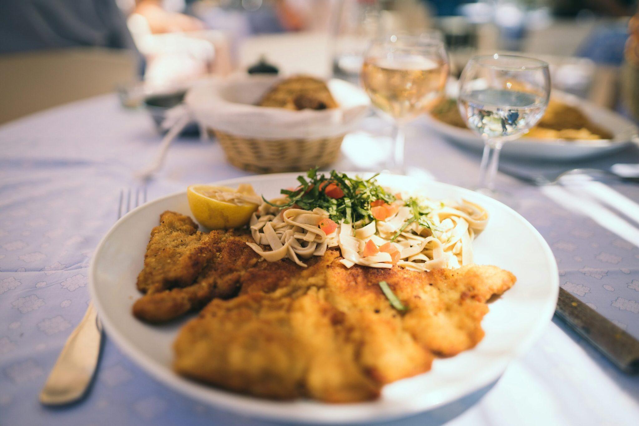 Ein Teller Meeresfrüchte mit Pasta und gebratenen Garnelen, serviert beim Abendessen auf einer Terrasse