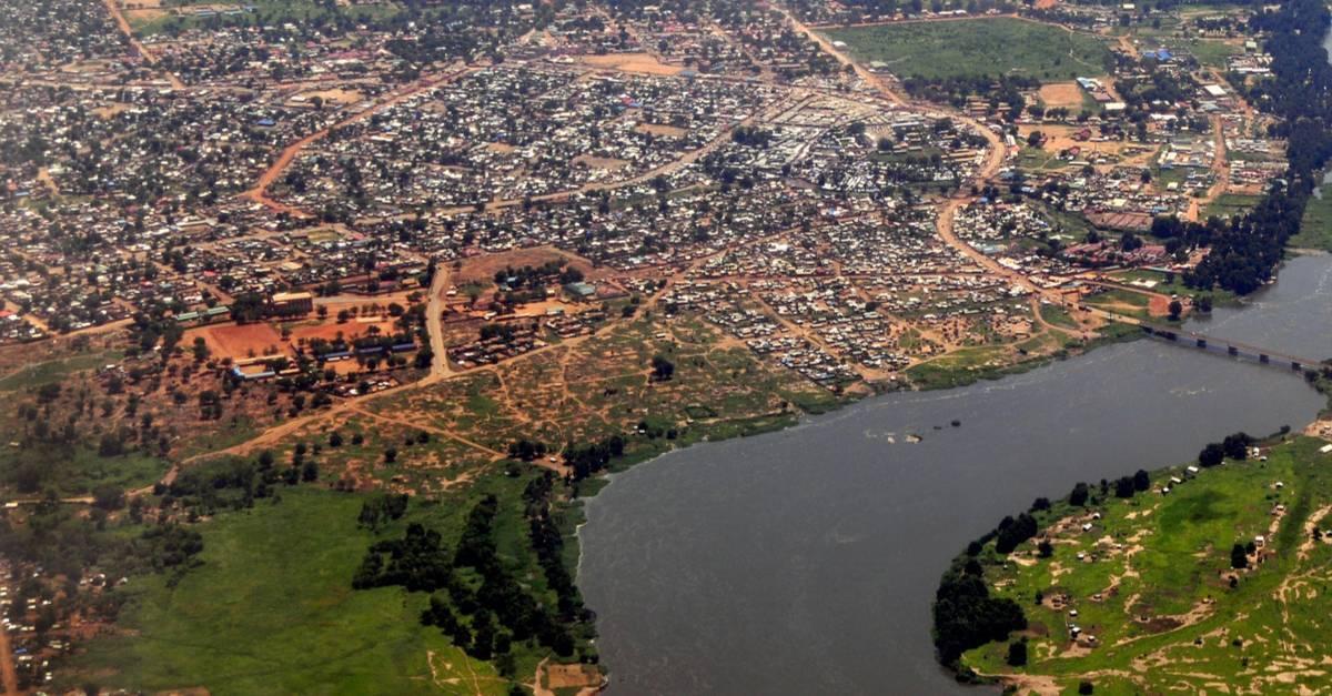 Vista aerea di una città africana con fiume, insediamenti sparsi e terre rosse caratteristiche