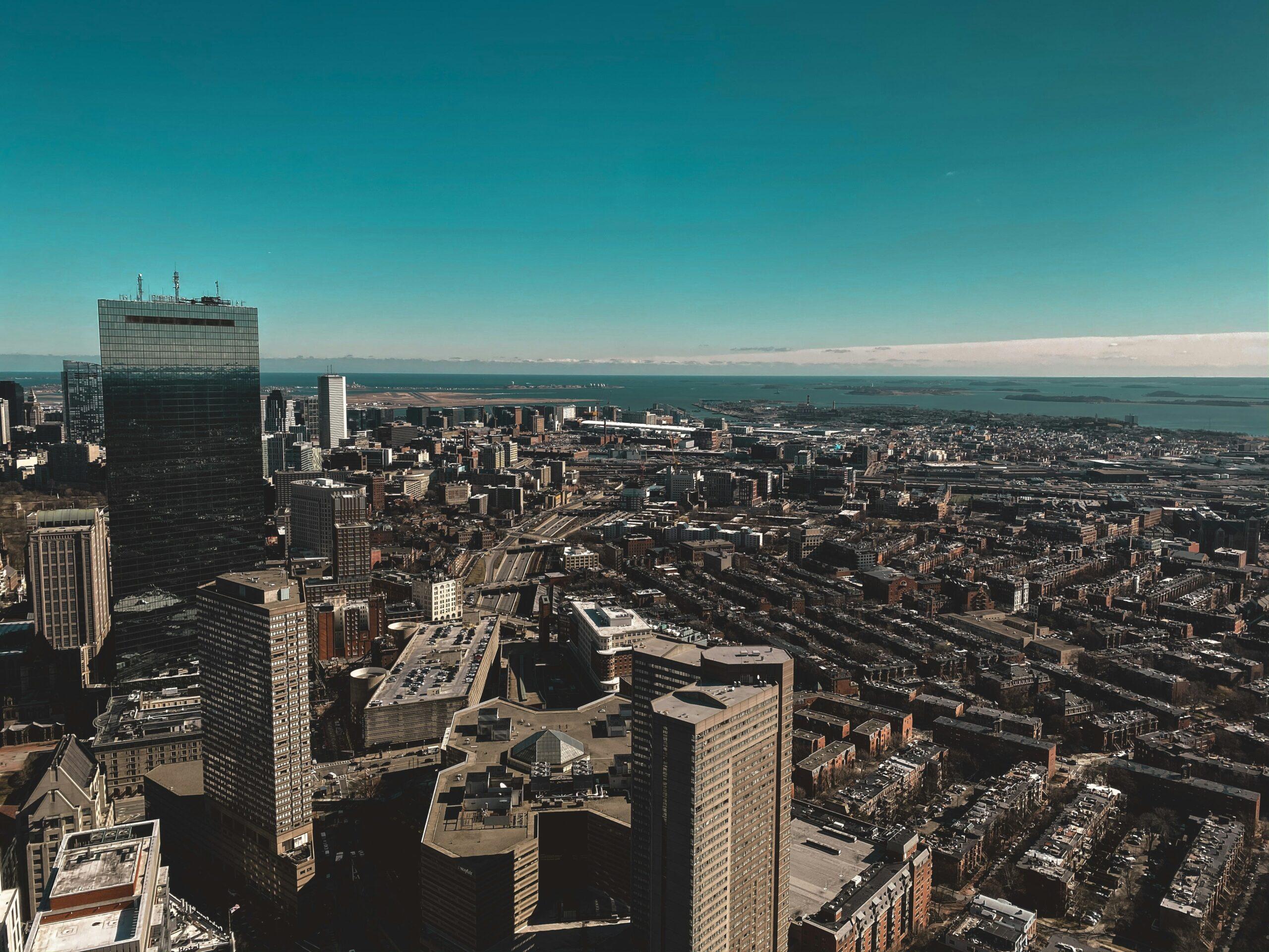 Aerial view of a coastal metropolis with skyscrapers, residential buildings and a turquoise bay in the background