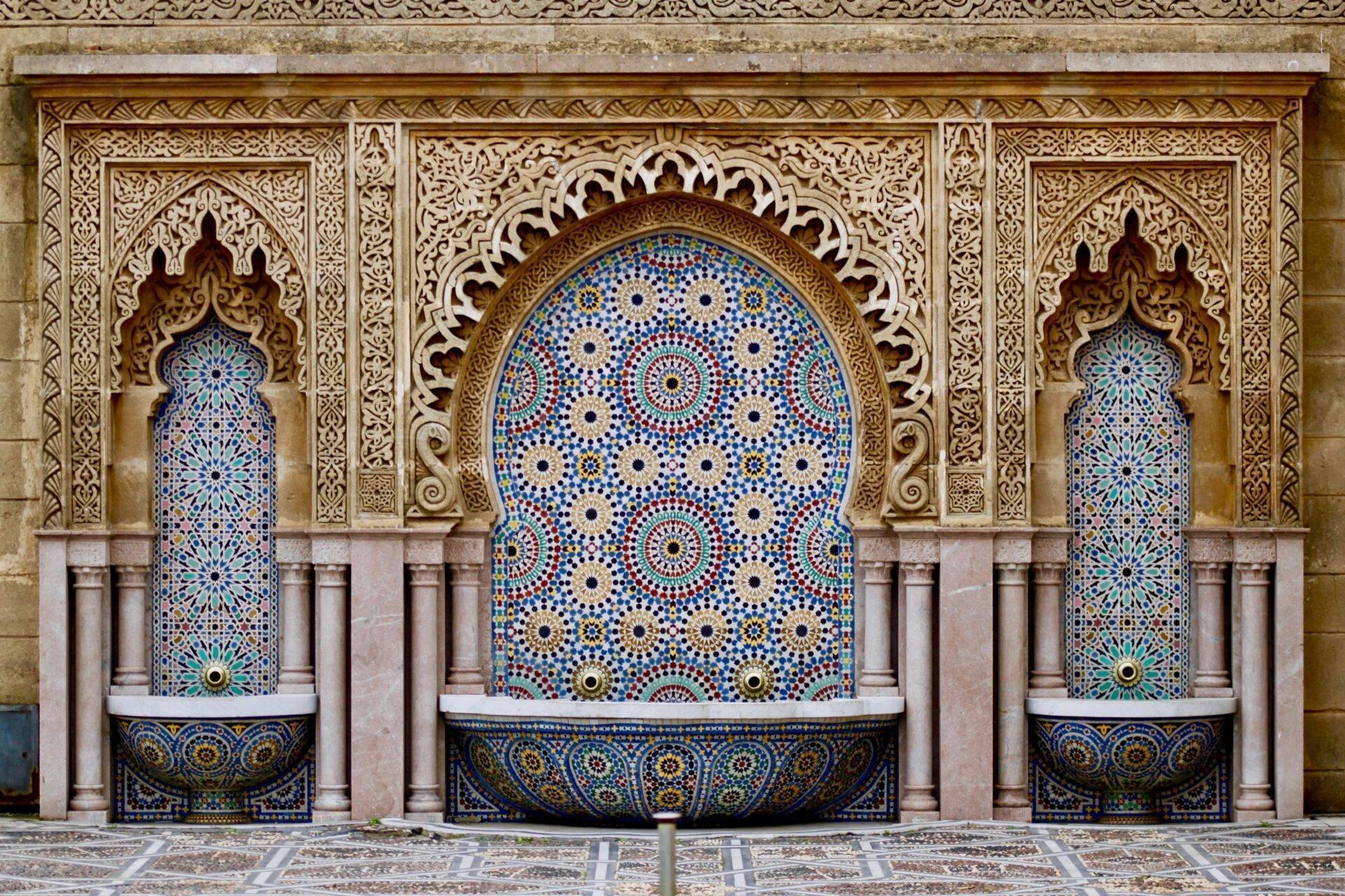 Drei mit blauen Zelliges und Schnitzholz verzierte Brunnen in traditionell marokkanischem Architekturstil