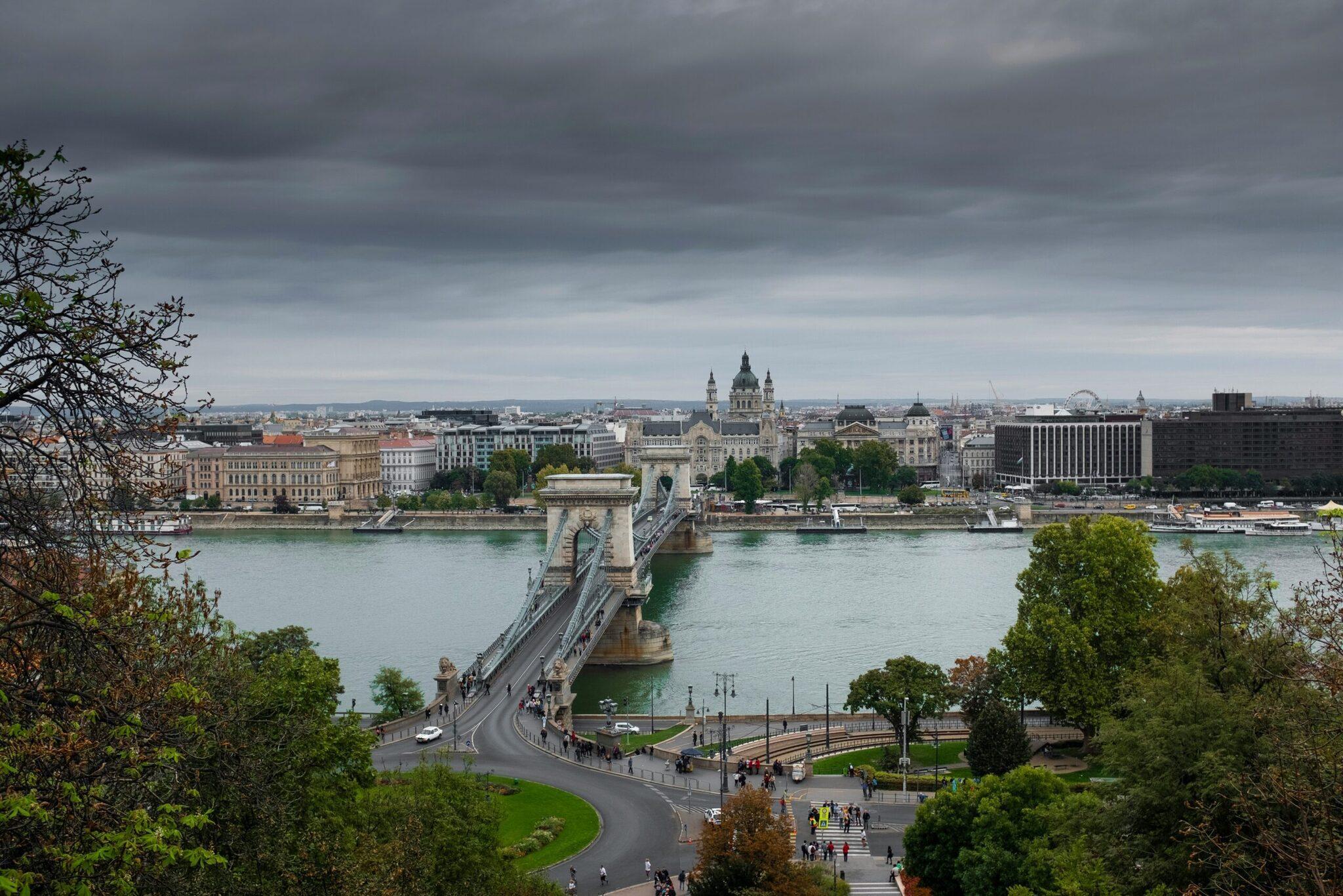 Panoramic view of a stone bridge crossing the Danube with a major basilica and historic buildings in the background