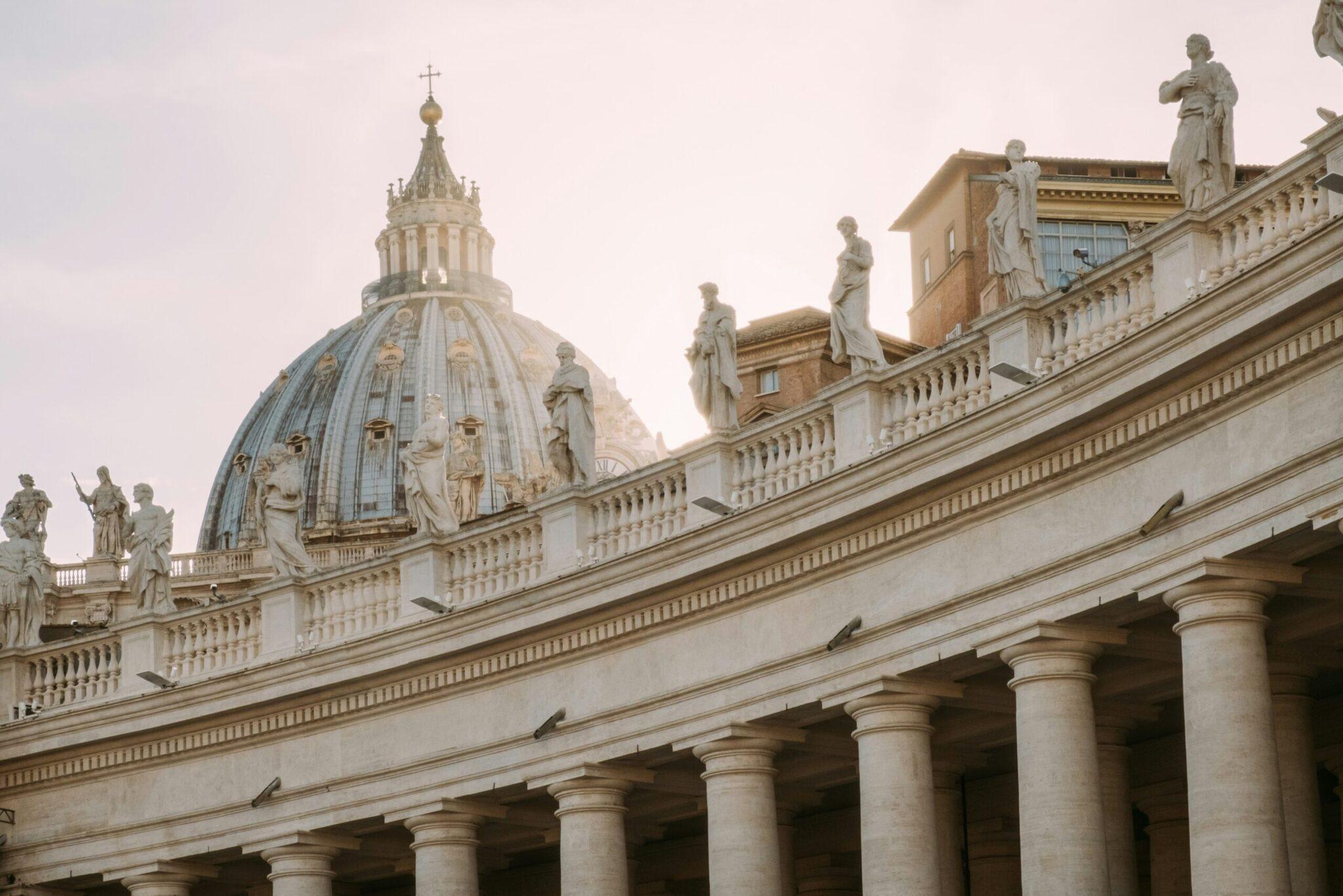 Columnata y cúpula de una basílica mayor con estatuas, arquitectura clásica grandiosa y cielo claro
