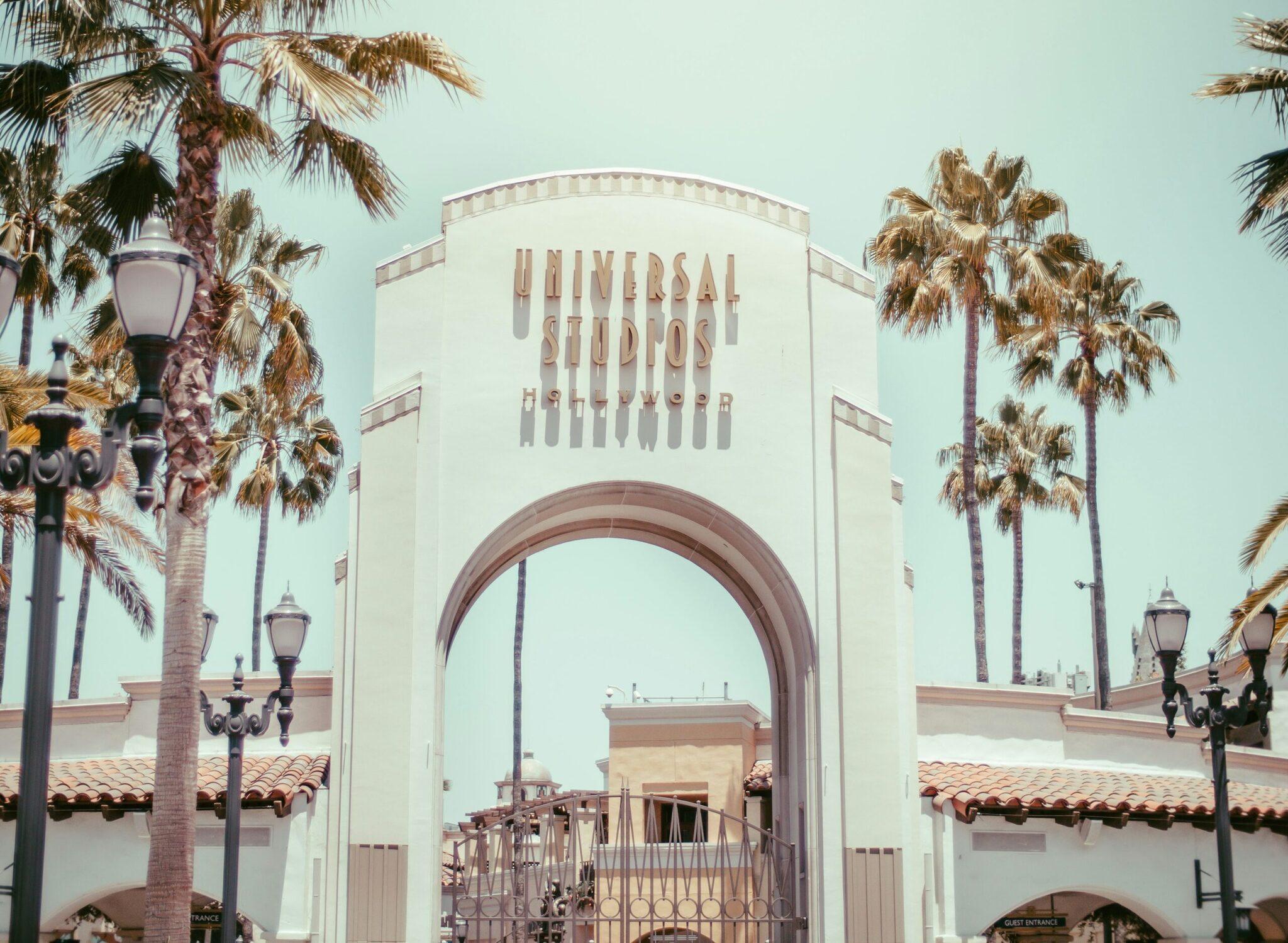 El famoso arco de entrada de Universal Studios Hollywood rodeado de palmeras bajo un cielo despejado