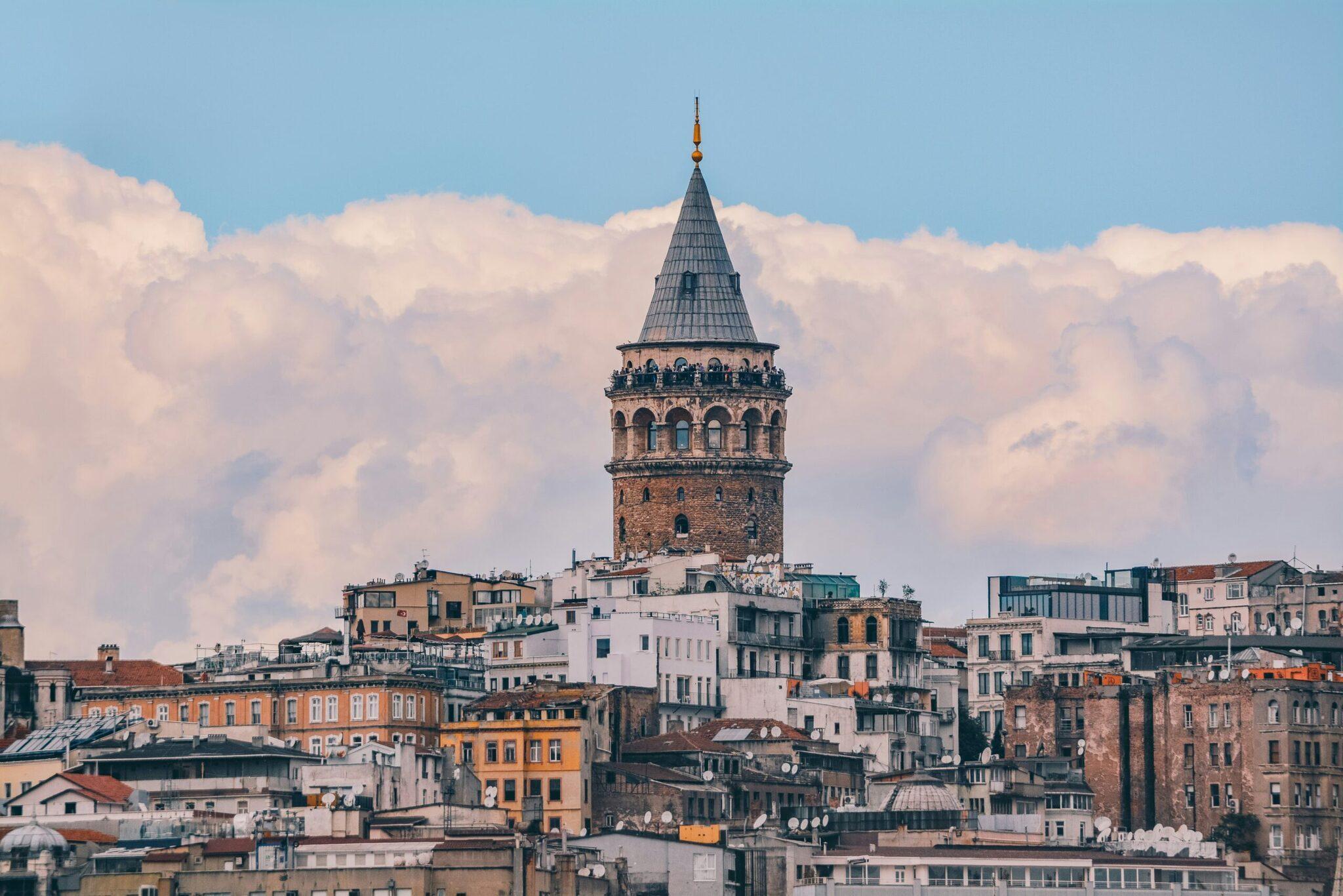 La Torre di Galata domina lo skyline di Istanbul con i suoi edifici storici colorati sotto un cielo nuvoloso