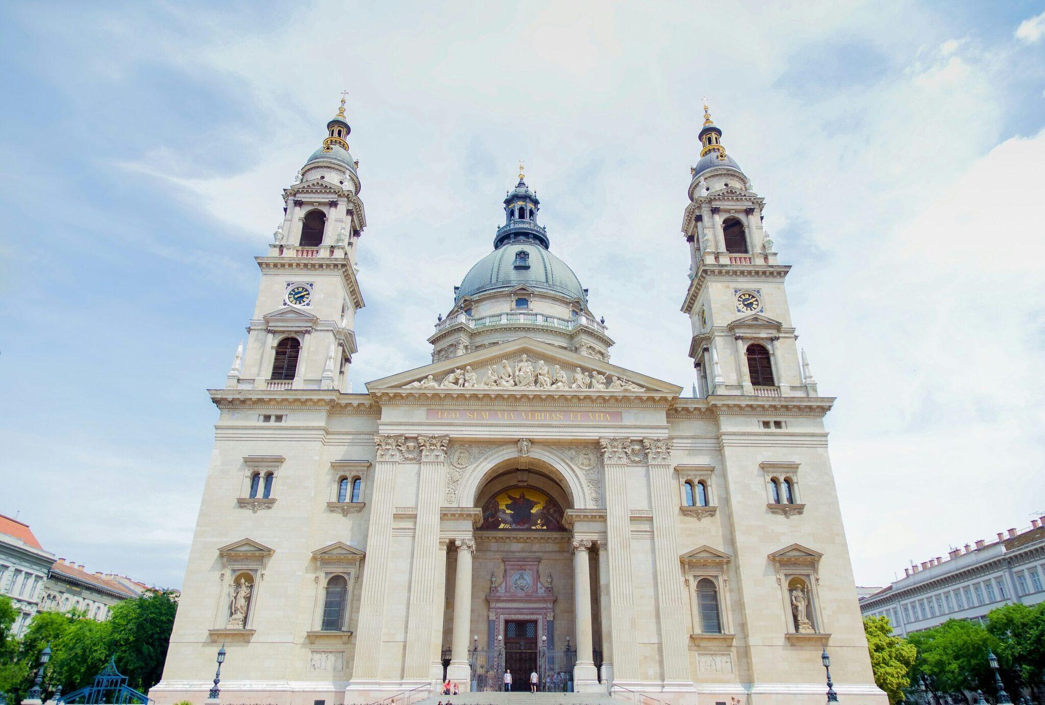 Majestic facade of a neoclassical basilica with a blue dome and two symmetrical white towers