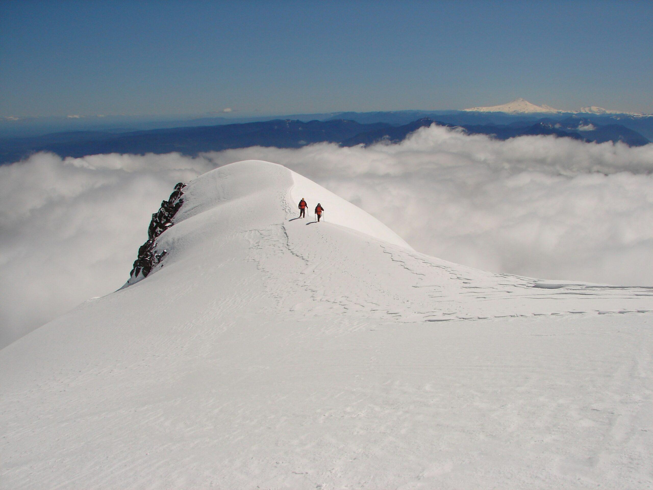 Alpinistes équipés de crampons lors de l’ascension du volcan Villarrica au Chili, avec le cratère actif en arrière-plan