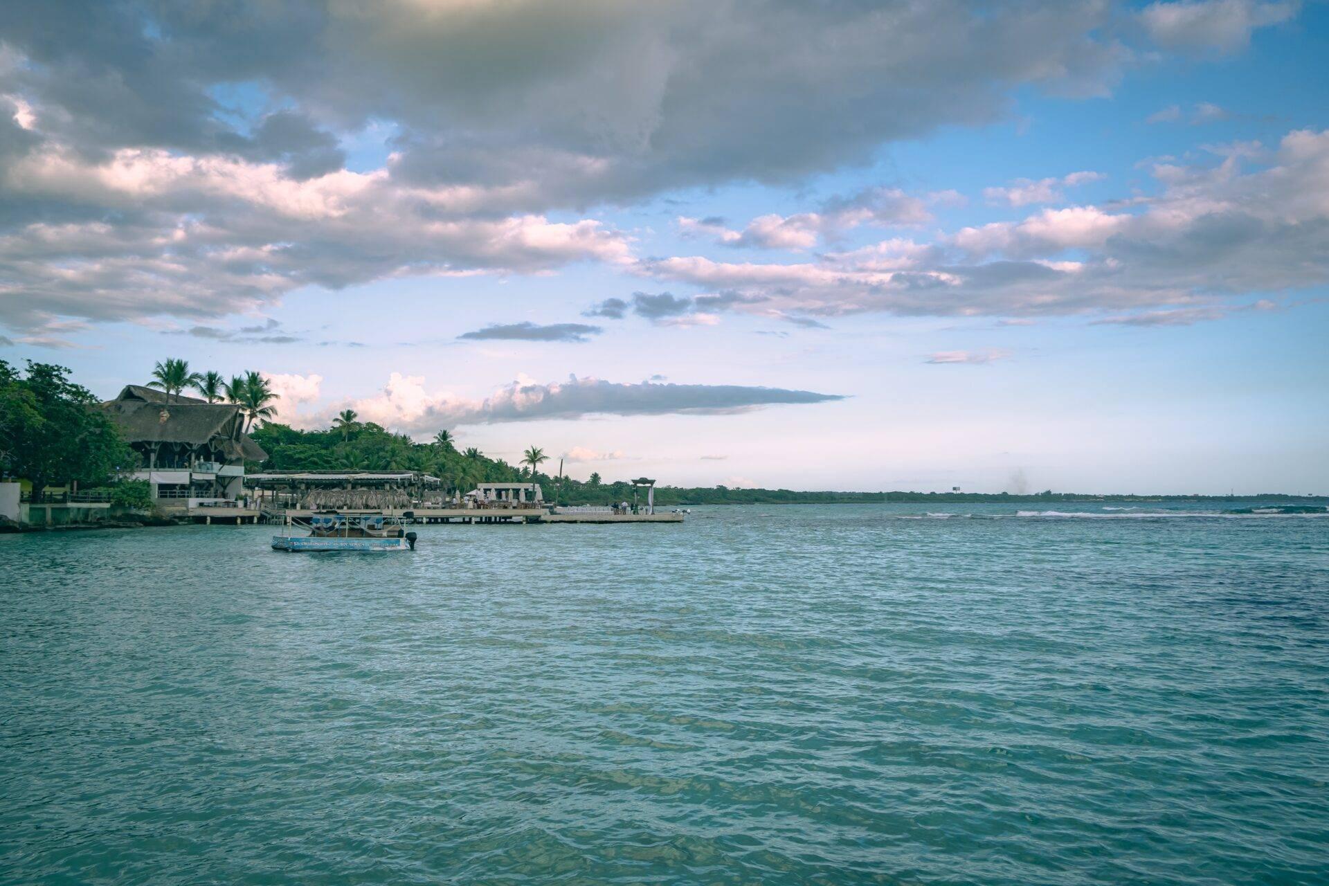 Calm, clear lagoon at Boca Chica with bathers and palm trees along the shore